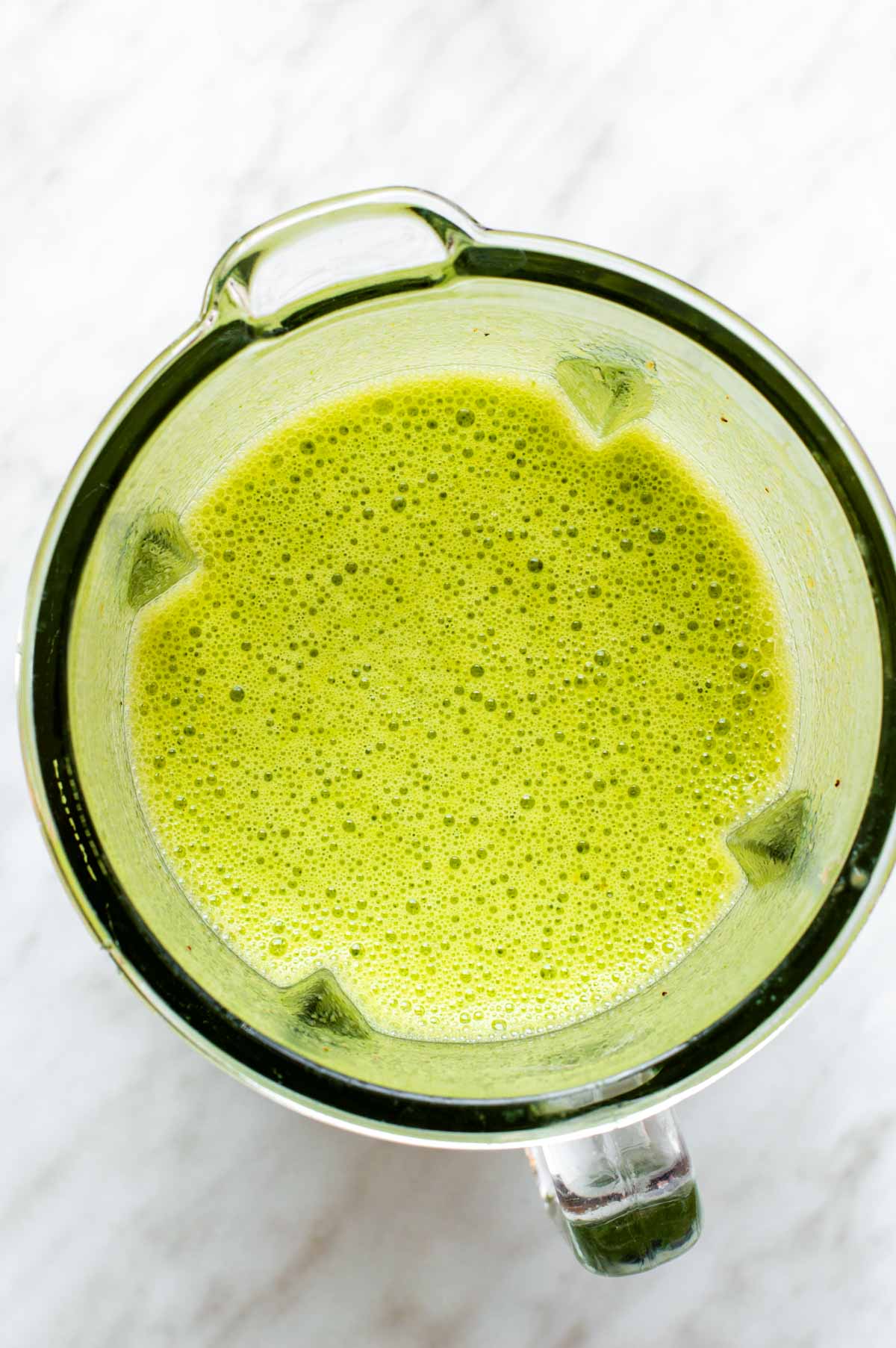 Green tea smoothie blended up in a blender.