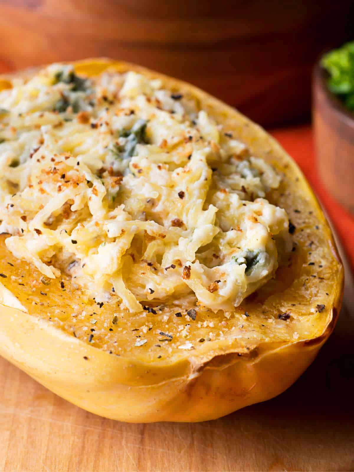 Spaghetti squash half topped with creamy sauces and herbs.