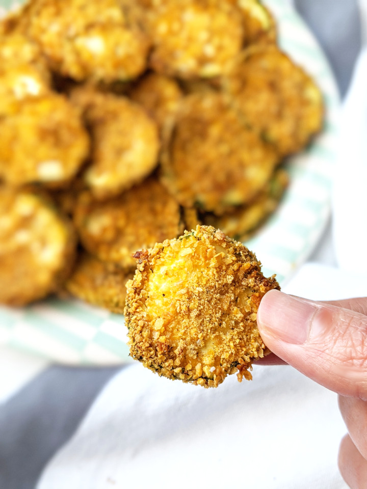 These Vegan Baked Zucchini chips are oven-baked, crispy, and irresistible! They're a delicious and healthy alternative to regular chips and are incredibly easy to make! #vegansnack #veganchips #healthysnack #easysnack #bakedchips #zucchinichips