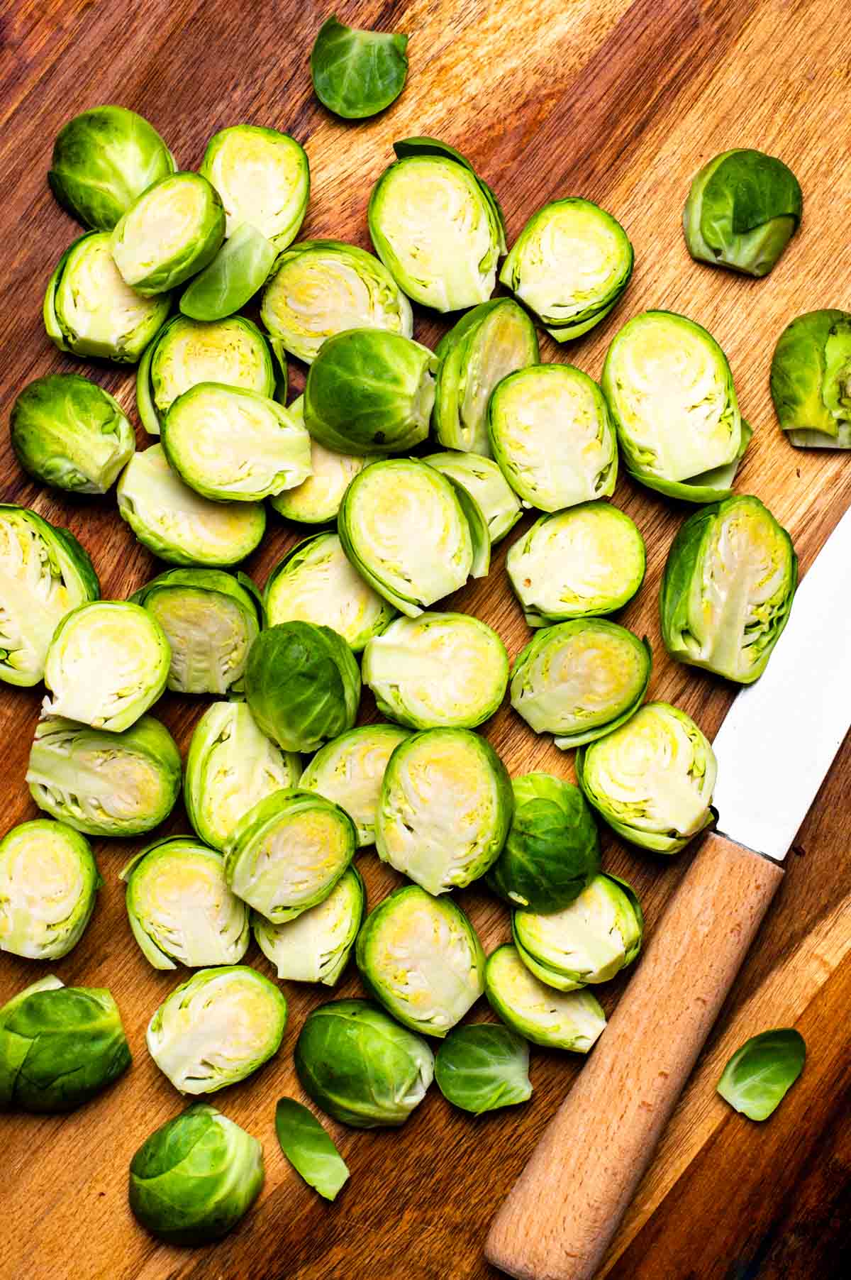 Prepared Brussels sprouts on a cutting board, sliced in half.