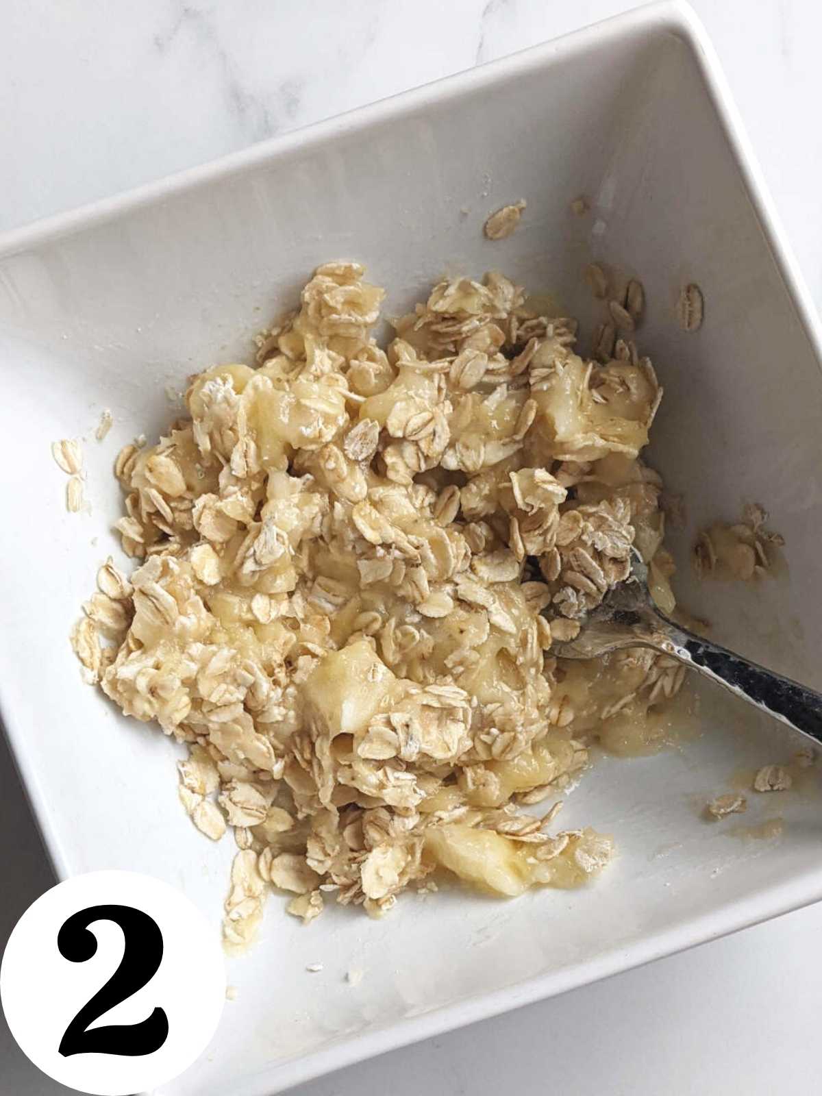 Mashed banana and oats mixed together in a bowl.