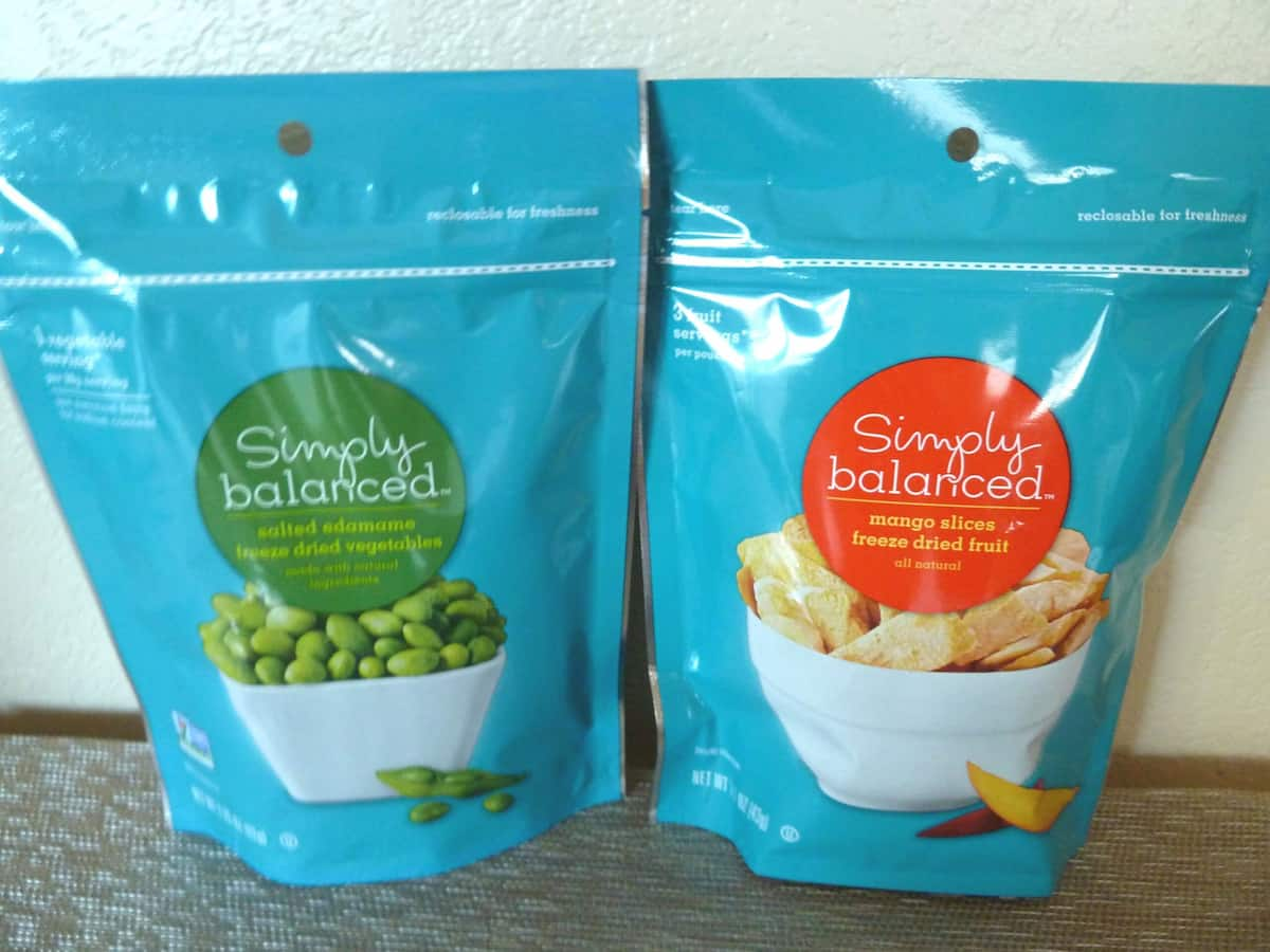 A bag of freeze dried peas and a bag of freeze dried mango side by side.