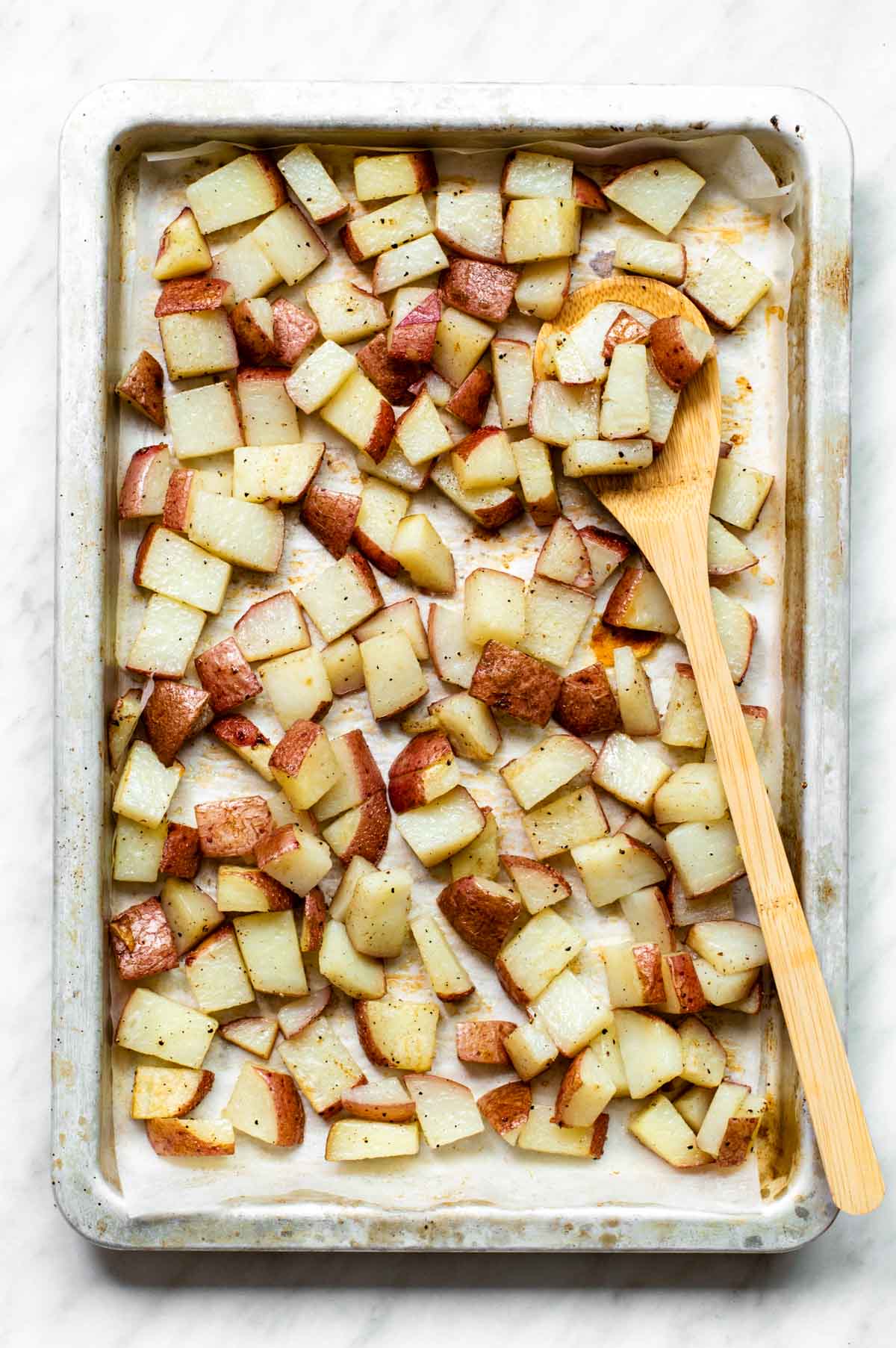 Cubed red potatoes on a baking tray.