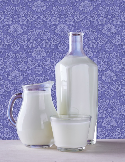 A glass, a jug, and a large bottle all full of milk