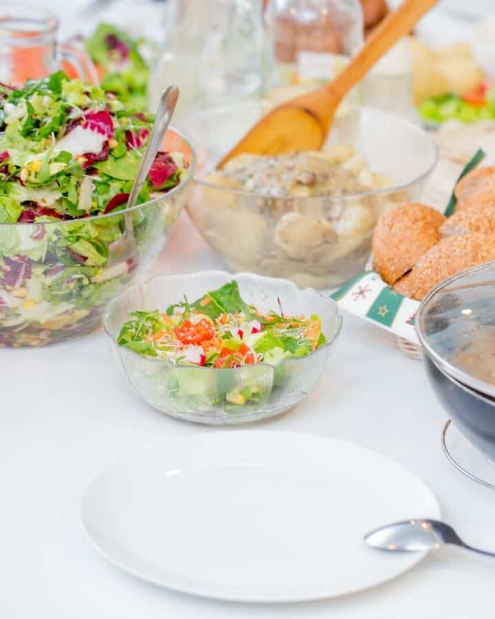 Potluck style table set with salad and other dishes.