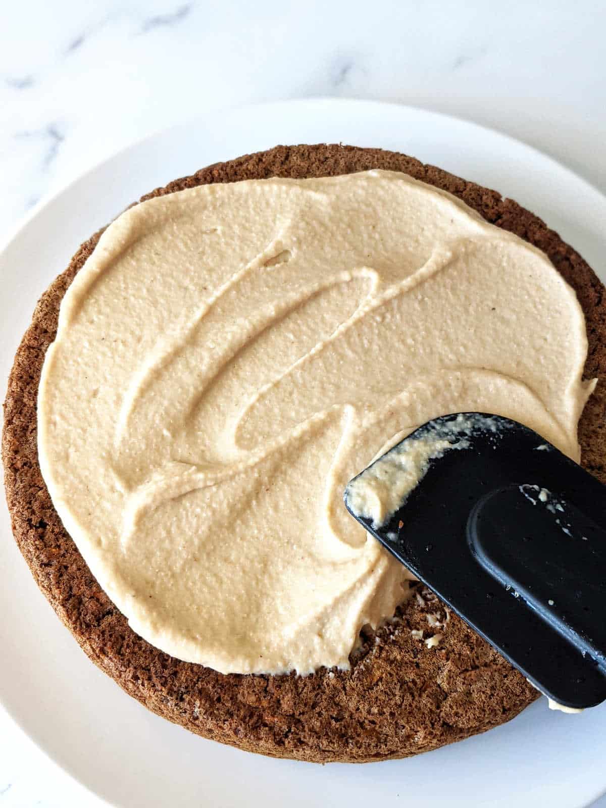 Frosting the cake with a silicone spatula.