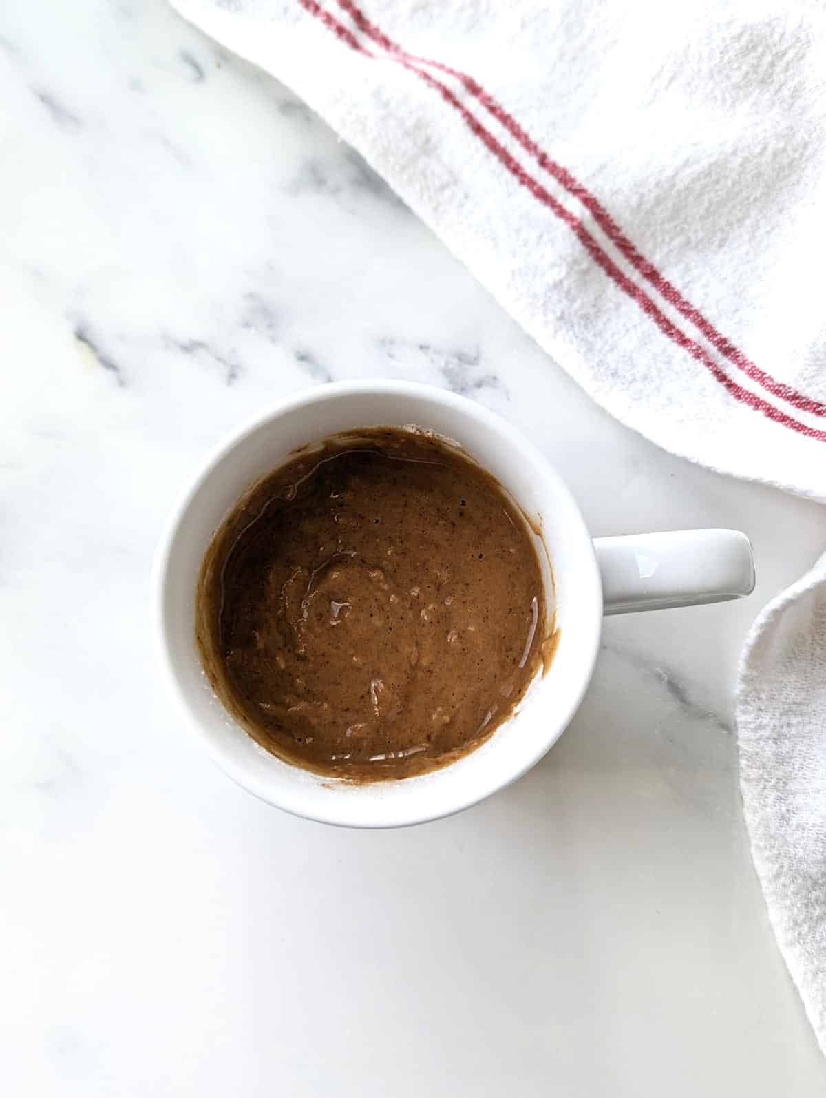 Mixed snickerdoodle cake batter in a mug.