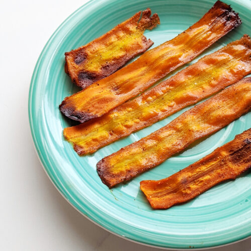 This carrot bacon recipe is so easy and great for when you want the delicious sweet and smoky-ness of bacon! Just 8 simple ingredients, a peeler, and an oven or air-fryer is all you need. Vegan bacon can be made in many ways but this carrot bacon is one of the simplest and most similar looking to actual bacon. And did I mention delicious? #carrotbacon #veganbacon #plantbased #vegan #veganrecipe #veganbreakfast #plantbasedbreakfast #meatfree #meatlessmeals