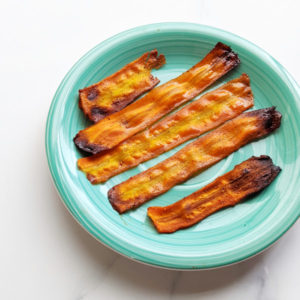 This carrot bacon recipe is so easy and great for when you want the delicious sweet and smoky-ness of bacon! Just 8 simple ingredients, a peeler, and an oven or air-fryer is all you need. Vegan bacon can be made in many ways but this carrot bacon is one of the simplest and most similar looking to actual bacon. And did I mention delicious? #carrotbacon #veganbacon #plantbased #vegan #veganrecipe #veganbreakfast #plantbasedbreakfast #meatfree #meatlessmeals