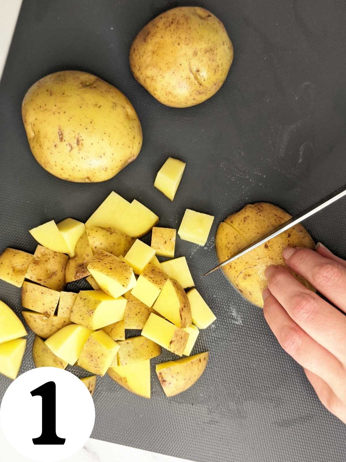 Slicing potatoes into ½ inch cubes.
