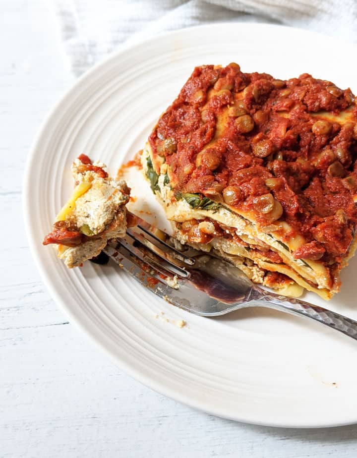 slice of lasagna on a plate with a fork