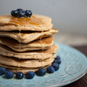 Stack of pancakes with blueberries and maple syrup