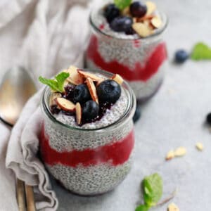 Berry chia pudding in jars topped with fruit and nuts
