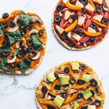 three healthy pita pizzas with lots of veggies and toppings