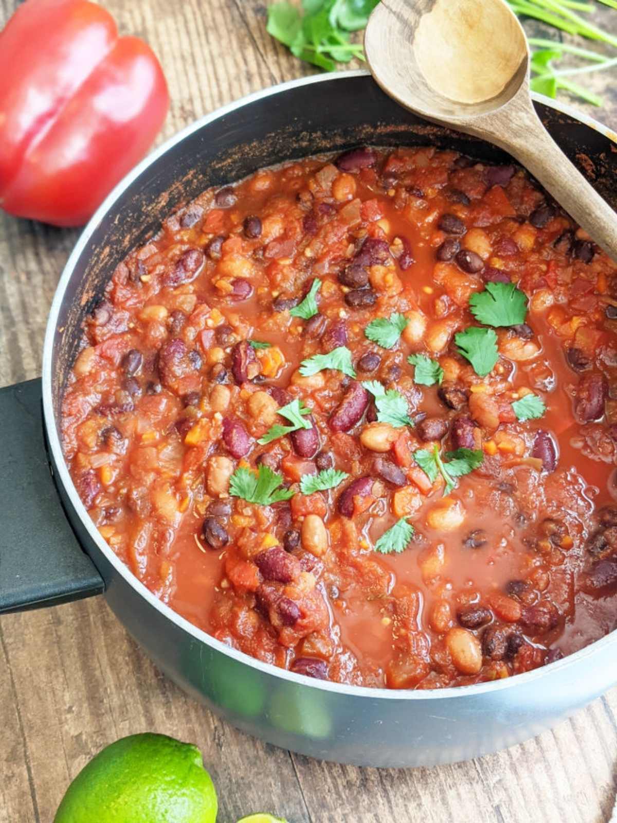 Large pot full of vegan chili topped with fresh chopped cilantro.