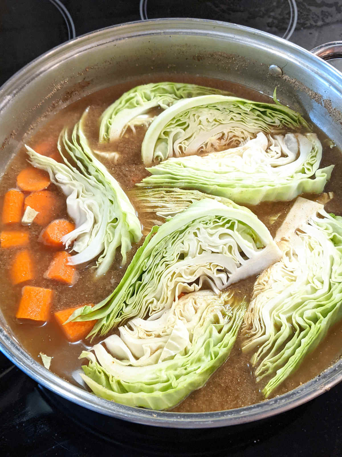 Braised cabbage and carrots in broth.