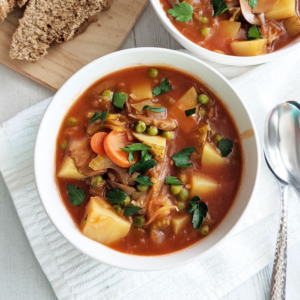 A bowl of vegetable stew topped with parsley