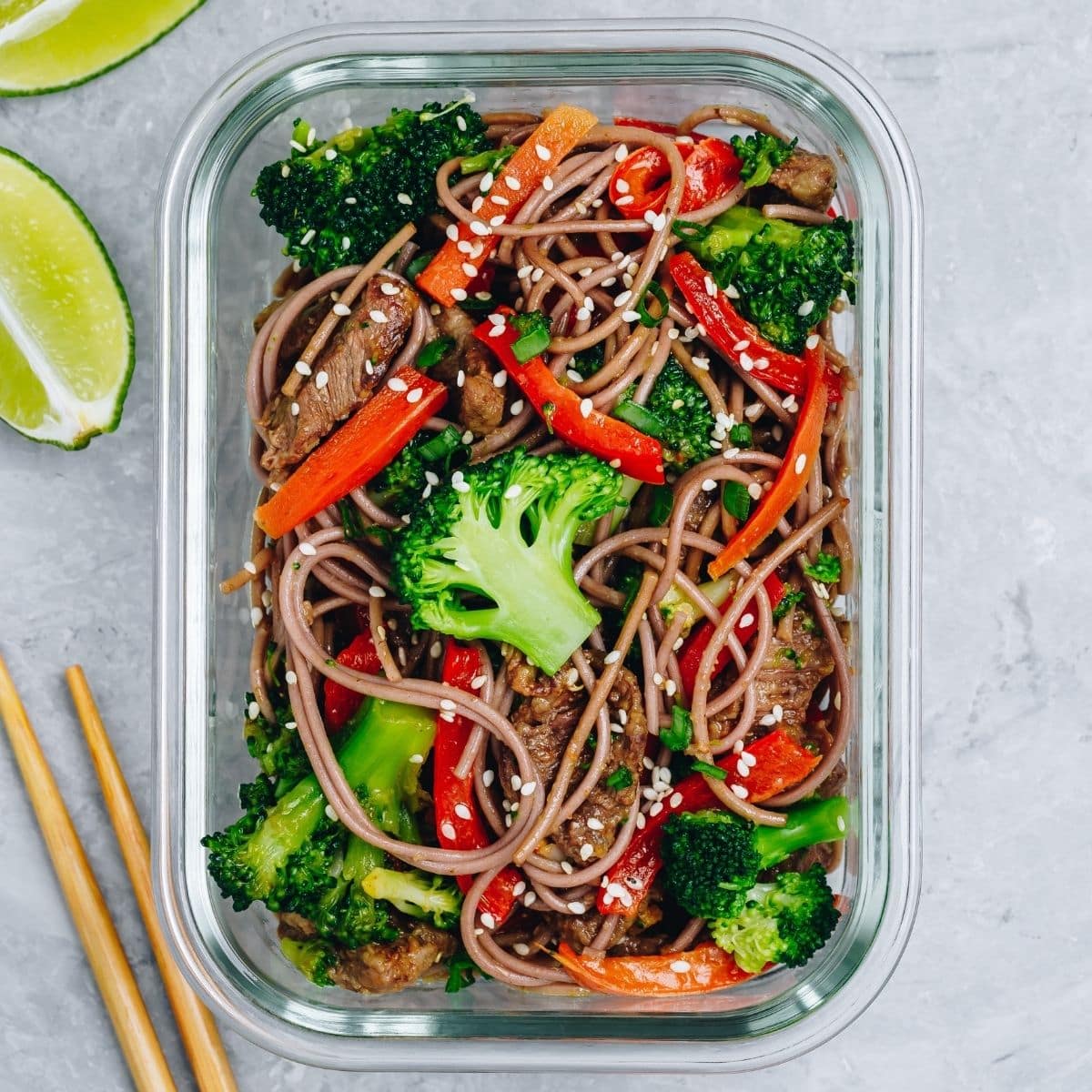 meal prepped noodle stir fry with veggies in a glass meal prep container