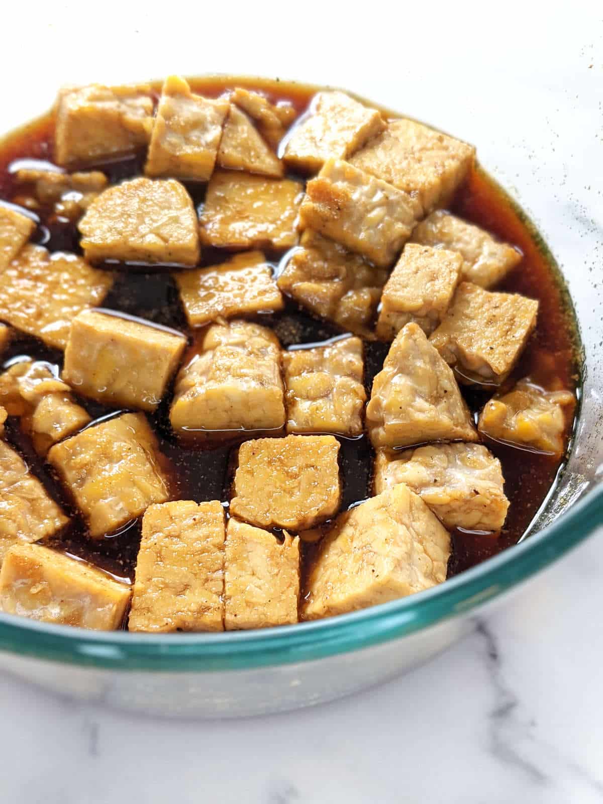 Cubes of tempeh soaking in marinade sauce