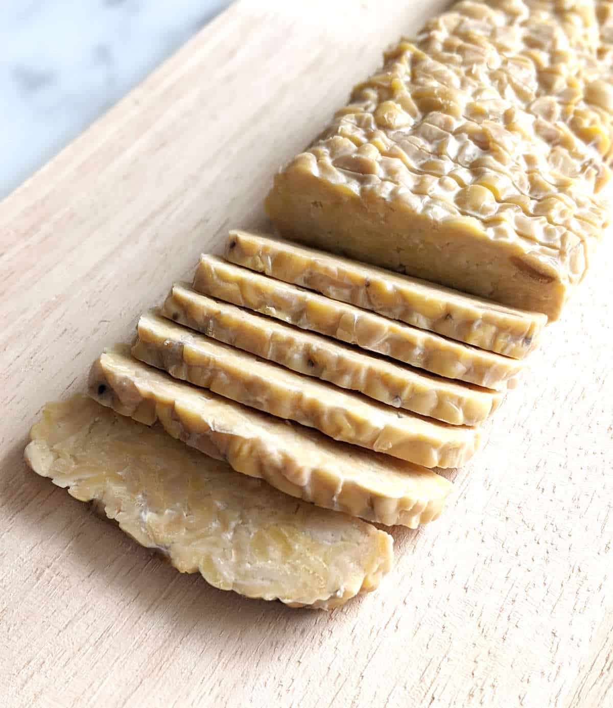 Sliced tempeh on a cutting board