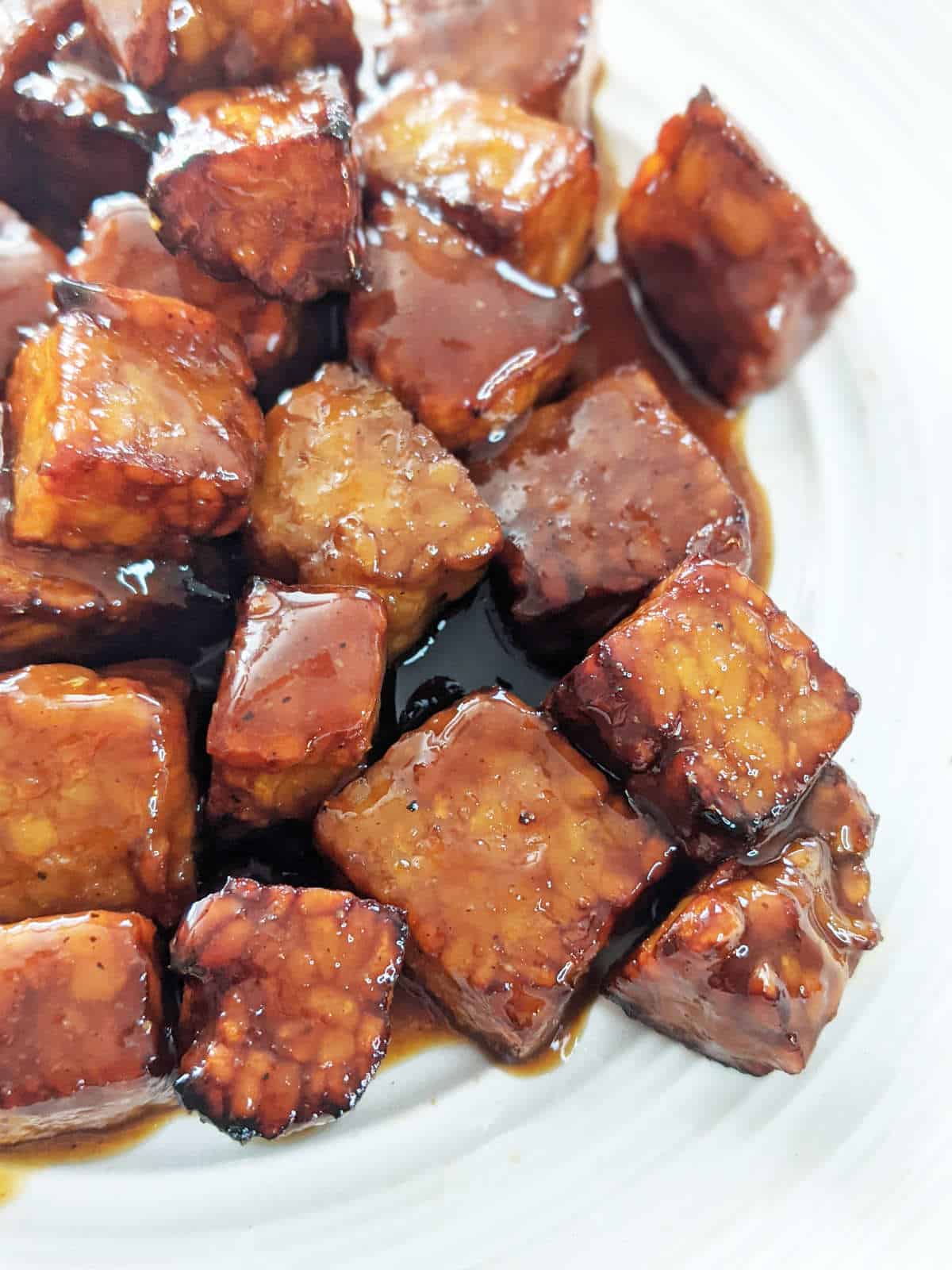 Up close of cooked tempeh smothered in sticky marinade