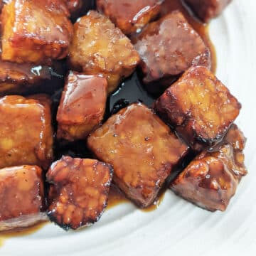 Up close of cooked tempeh smothered in sticky marinade