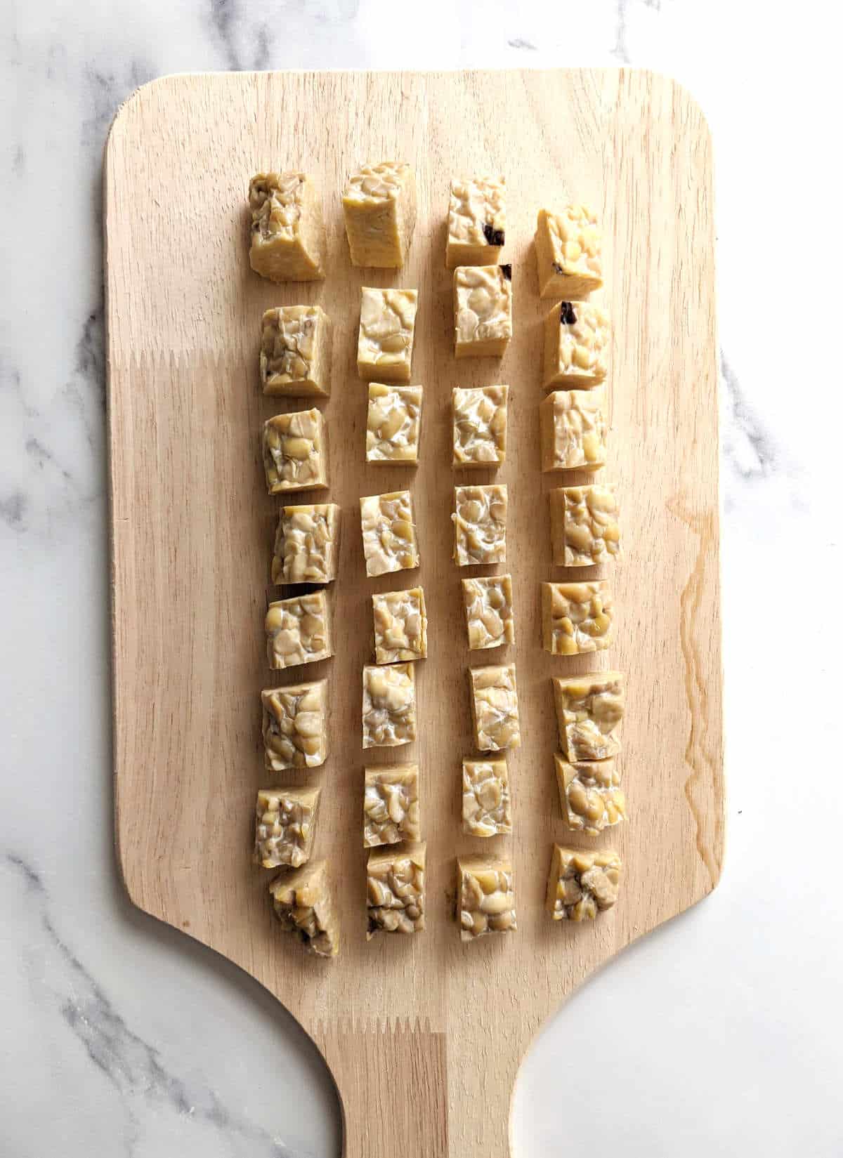 Cubed tempeh pieces on a cutting board