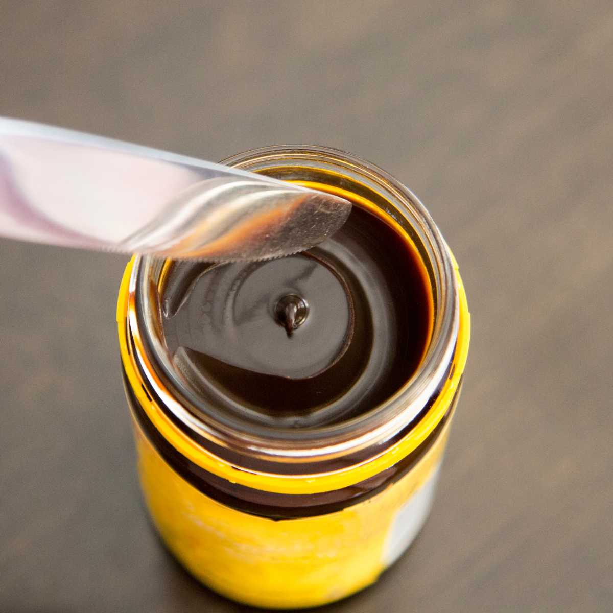 Yeast extract in a jar with a knife about to dip into it.