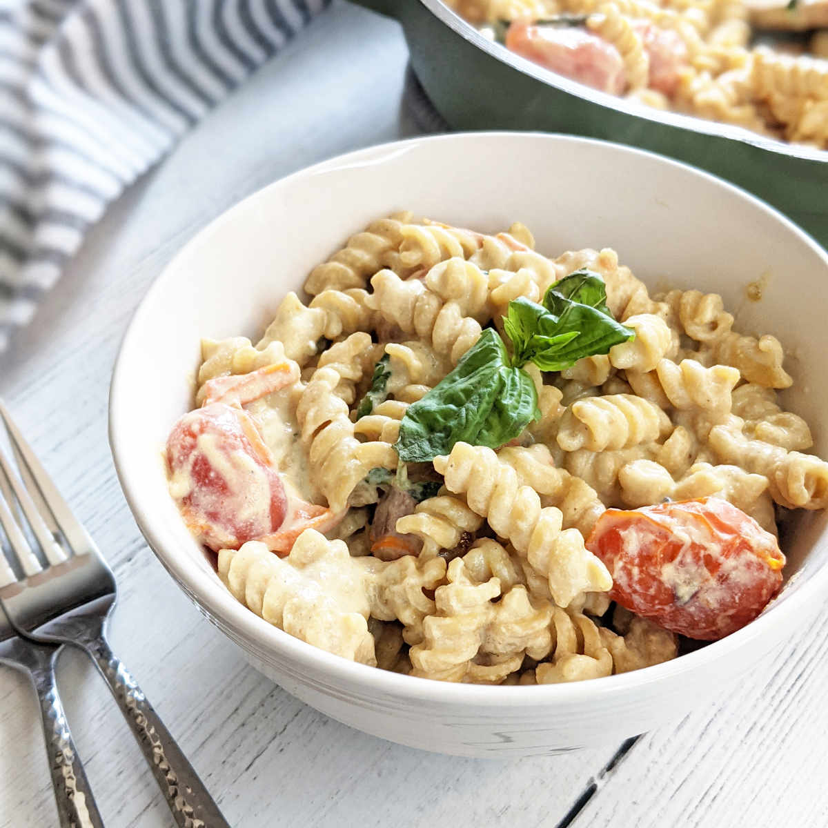 Bowl of vegan feta pasta topped with basil.