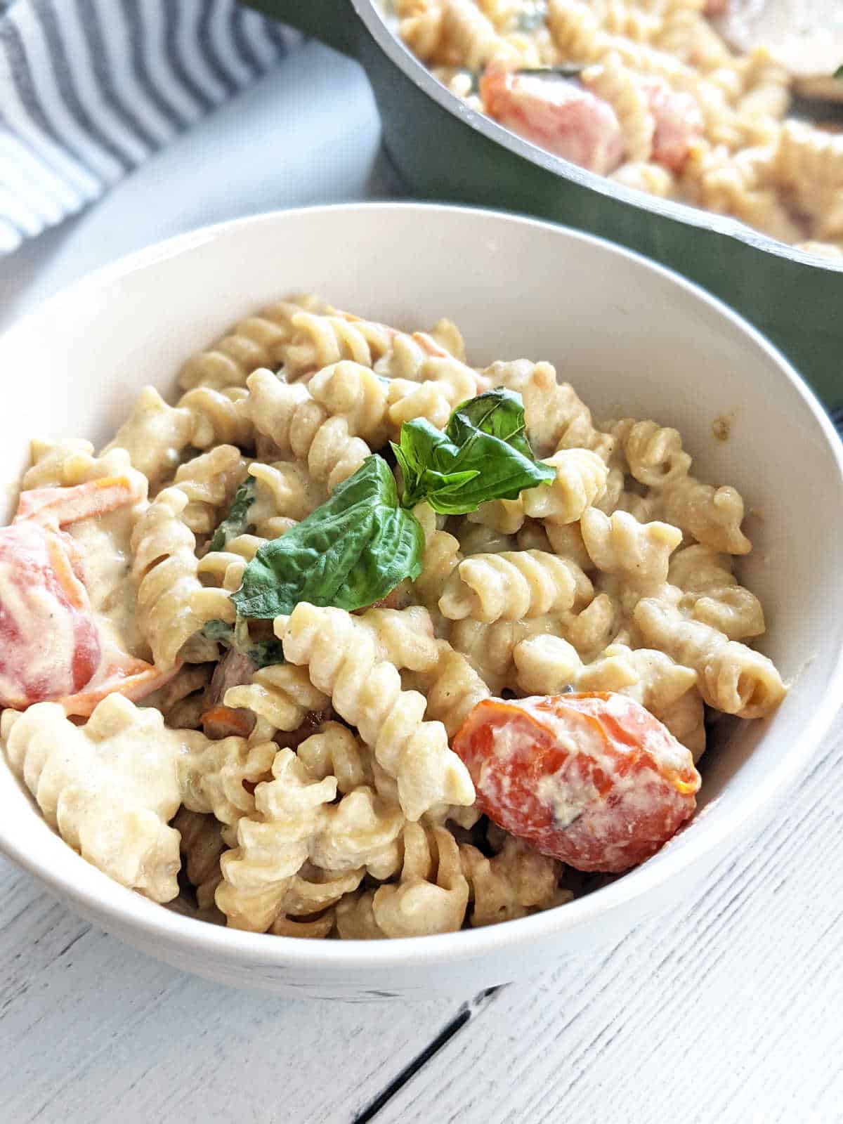 Vegan "baked" feta pasta in bowl topped with basil