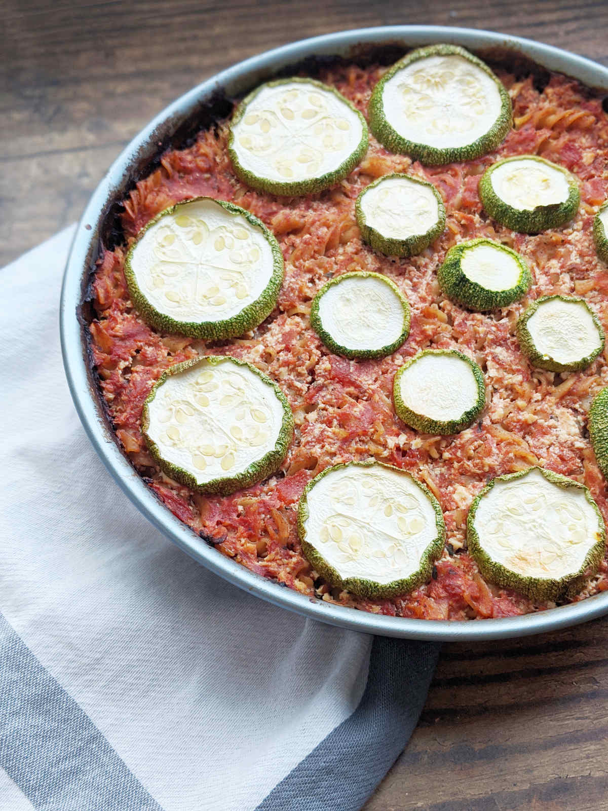 Pasta casserole topped with zucchini slices.