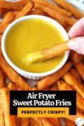 Hand dipping sweet potato fry into honey mustard with text overlay "Air Fryer Sweet Potato Fries perfectly crispy!"