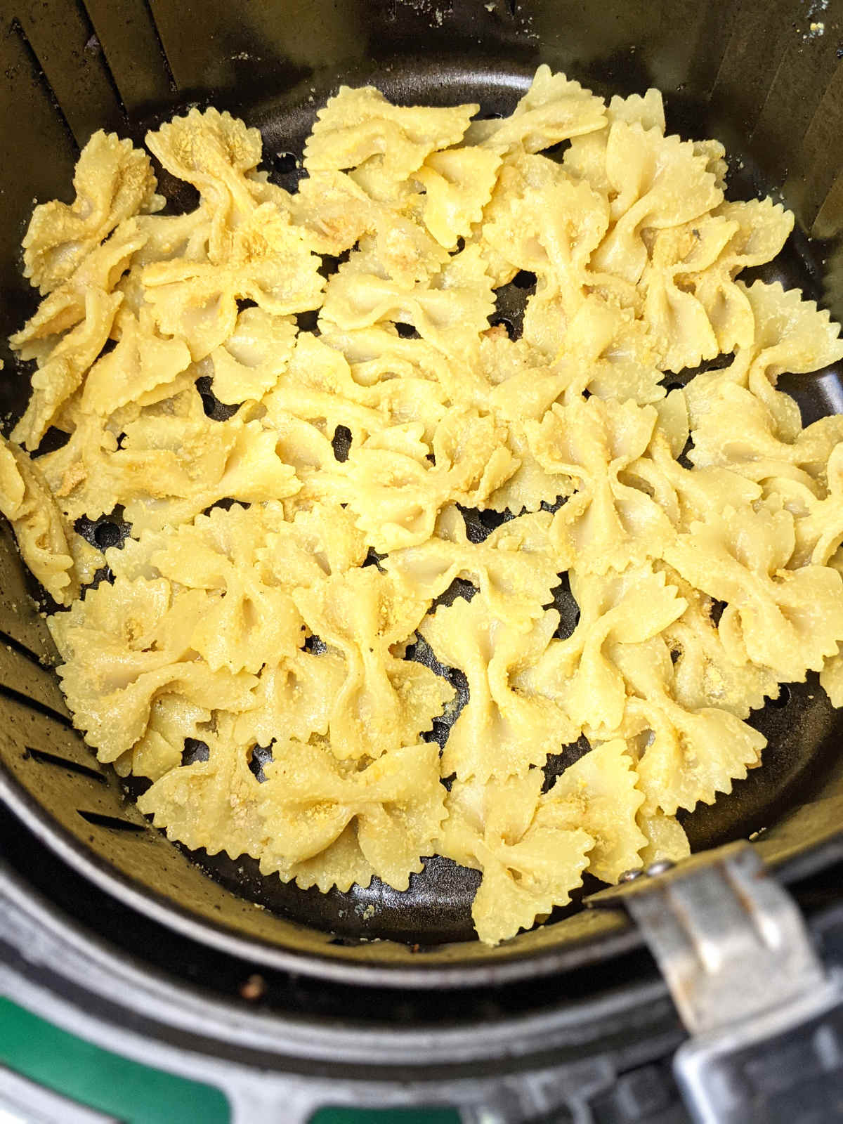 Pasta chips spread out in air fryer before cooking.