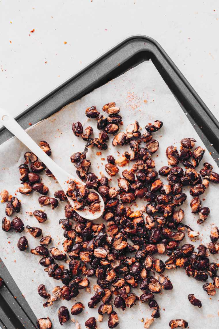 Roasted black beans on a baking tray.