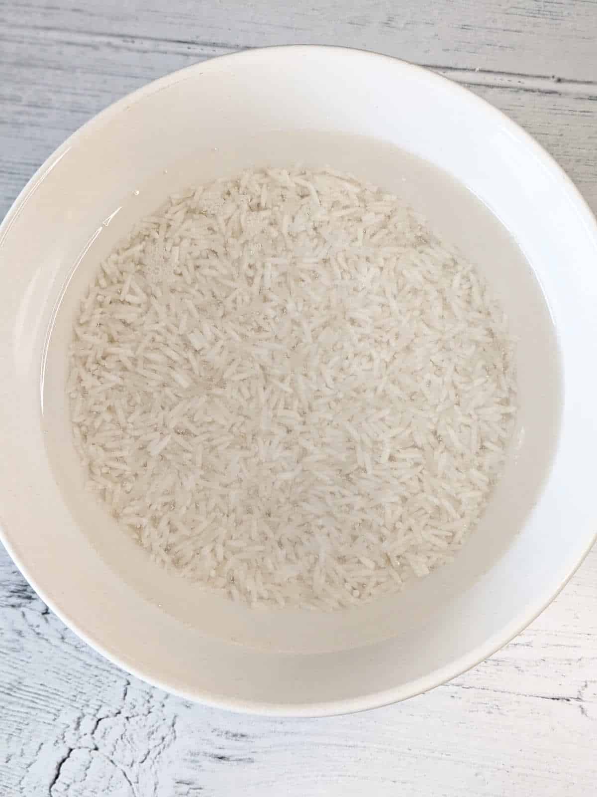 Rice soaking in a bowl with water.