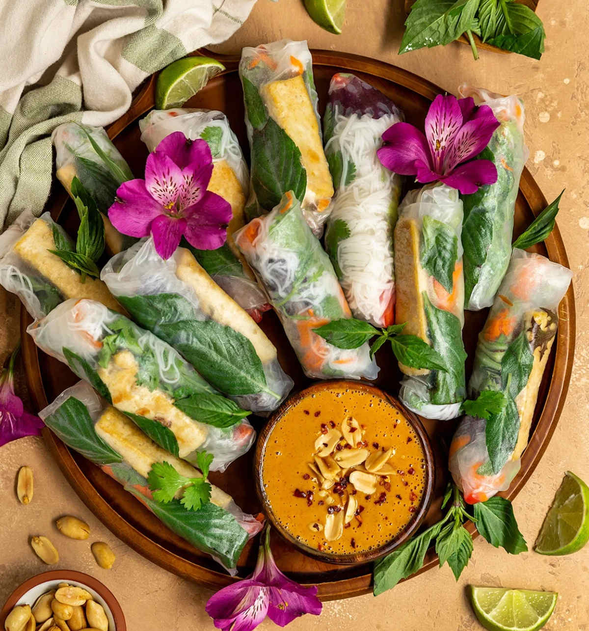 Tofu spring rolls on serving platter with small bowl of peanut sauce.