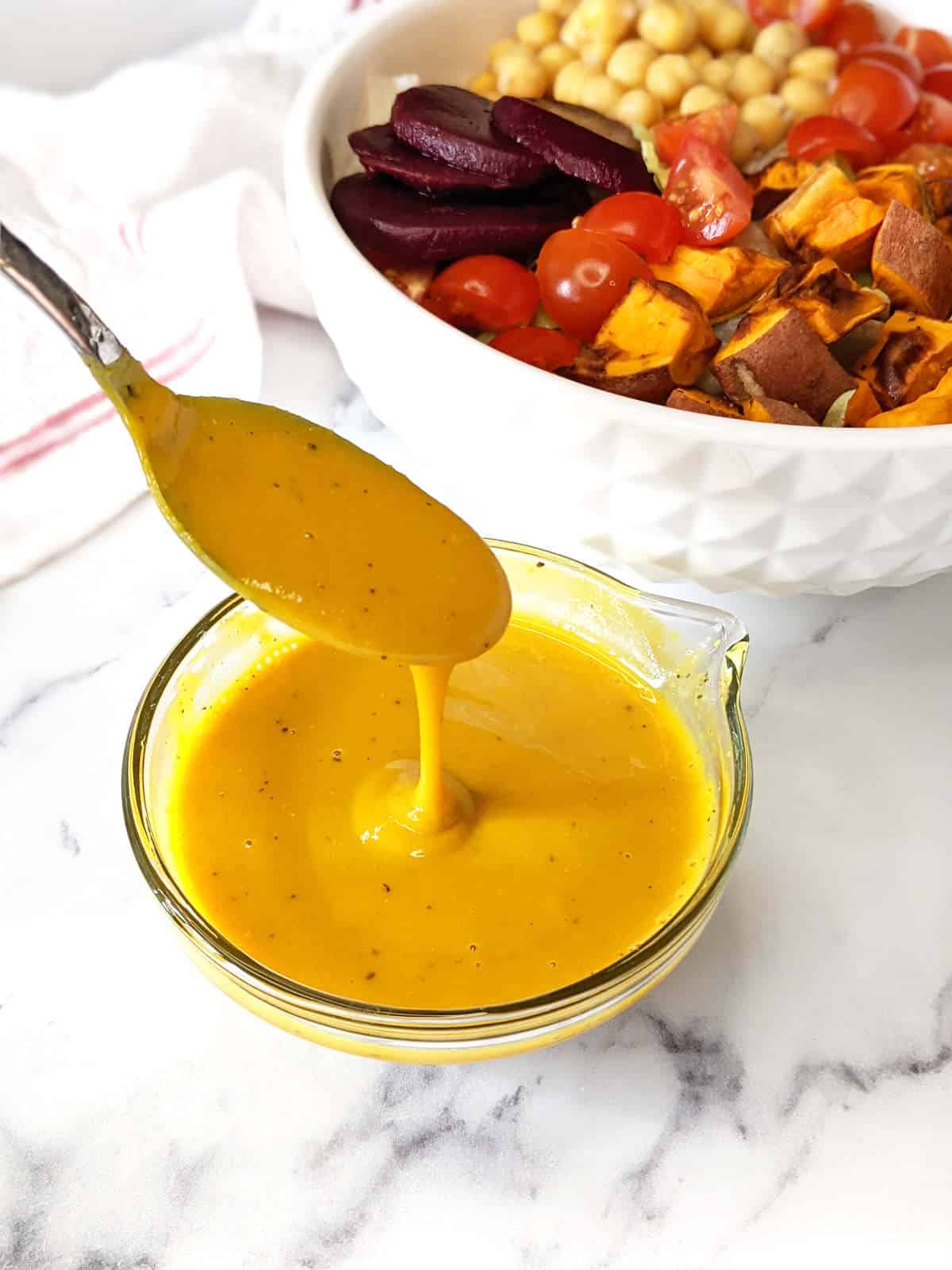 Vegan honey mustard dripping off a spoon.