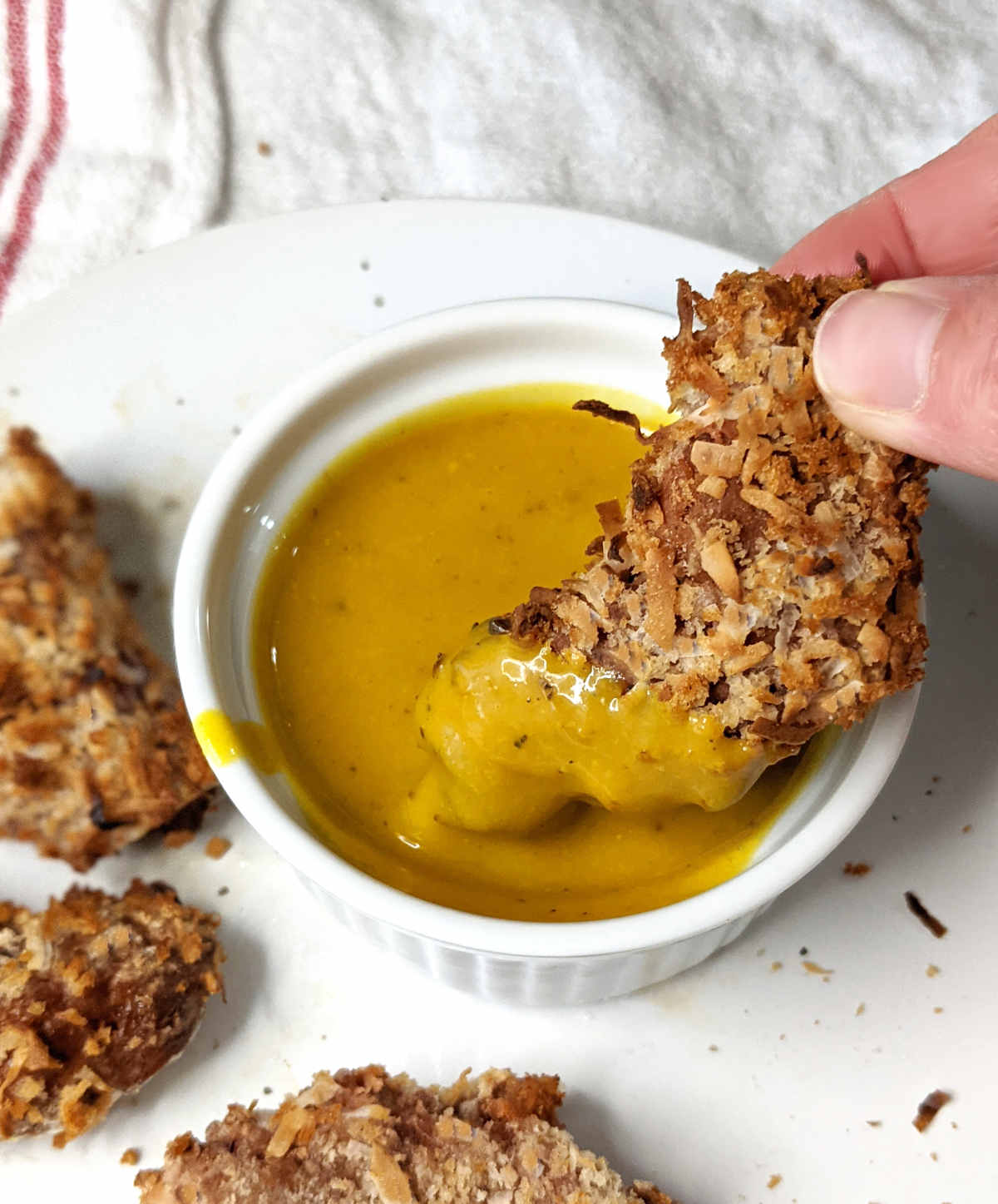 Vegan shrimp being dipped into vegan honey mustard.