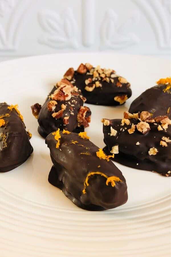 Chocolate covered dates on a plate.