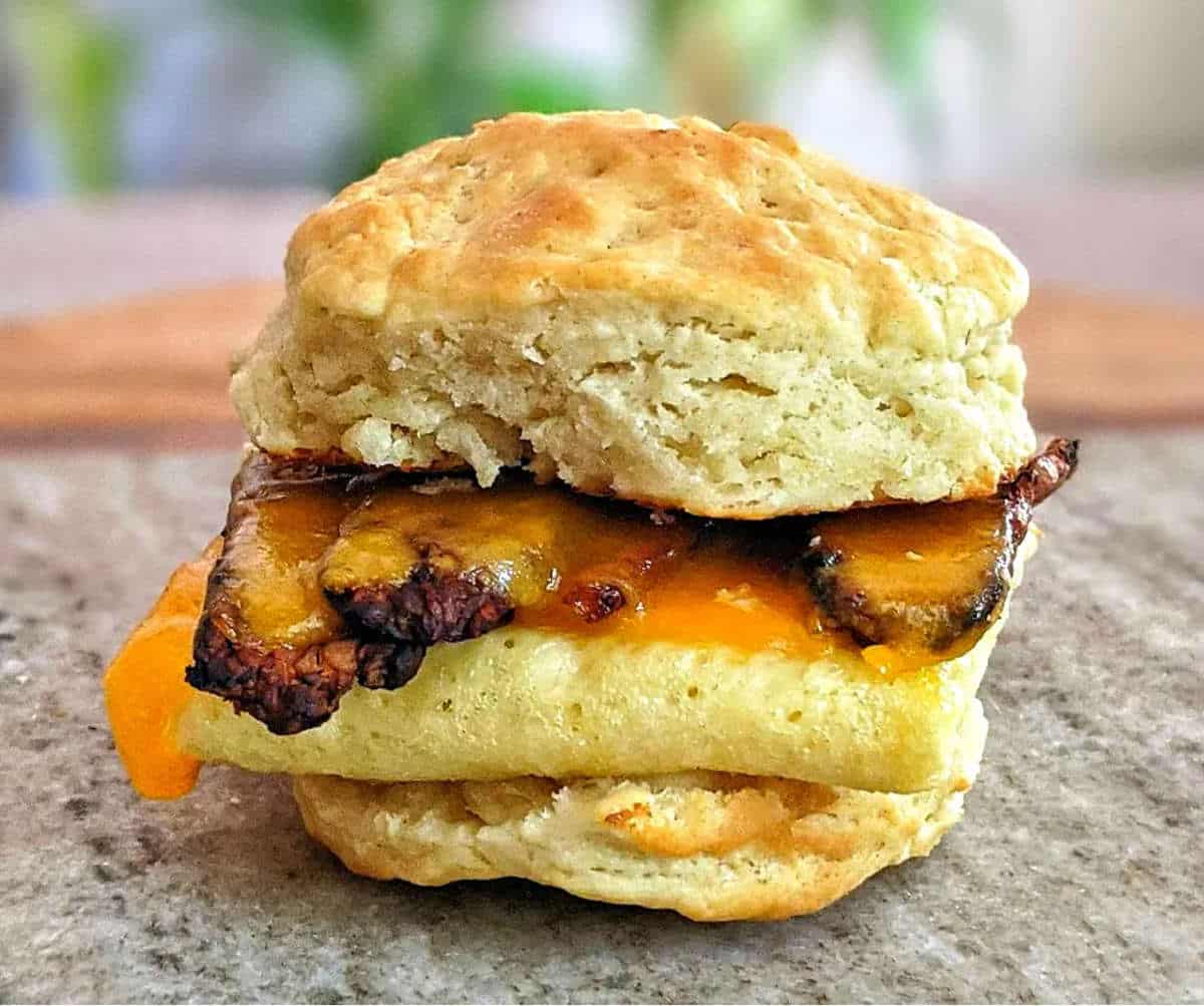 Biscuit sandwich with vegan bacon, cheese and fold Just Egg.