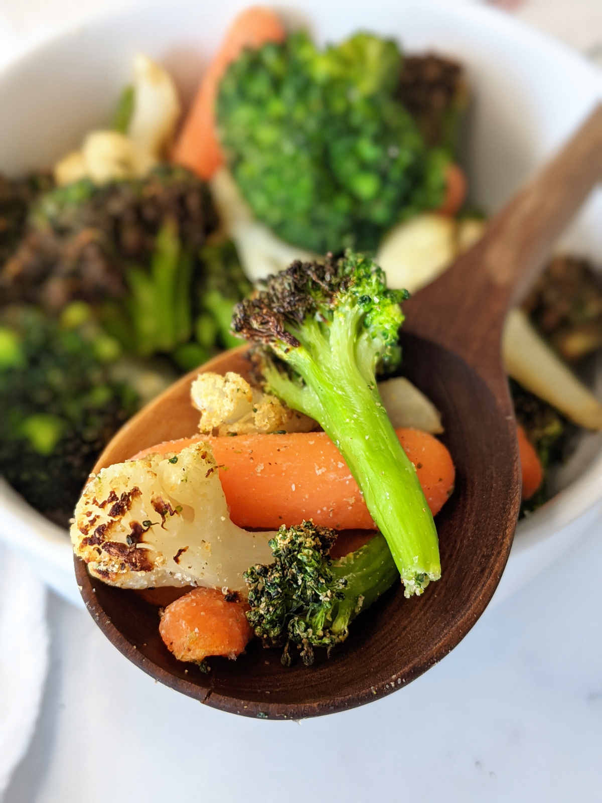 Roasted air fryer frozen vegetables on a serving spoon.