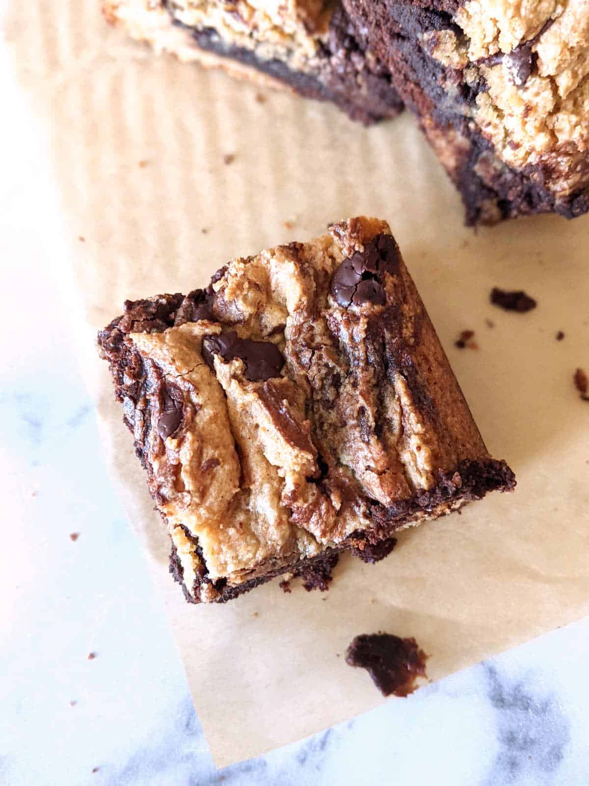 A slice of brownie blondies sitting on a parchment.