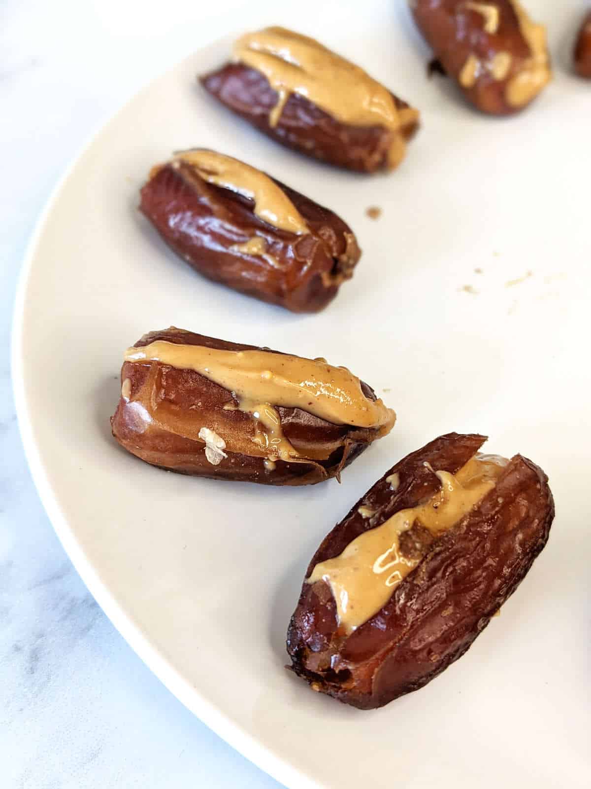 Dates stuffed with peanut butter on a plate.