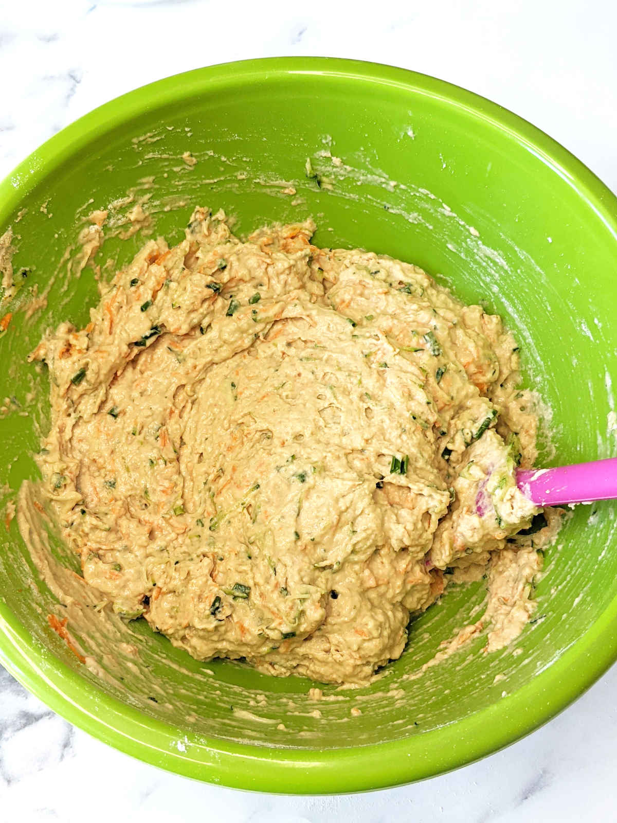 Vegan savory muffin batter mixed together in green mixing bowl.