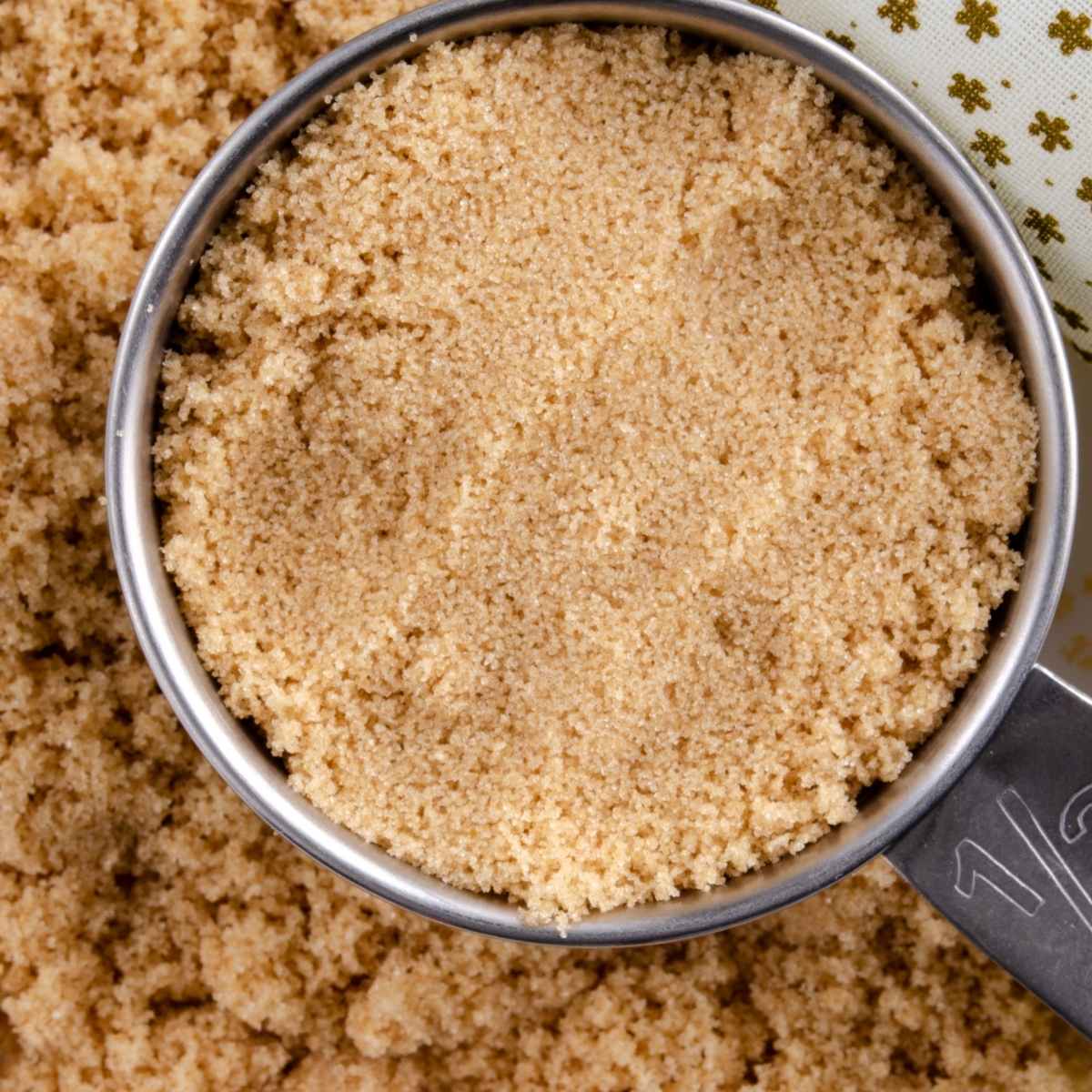 Homemade light brown sugar in measuring cup to use as substitute for coconut sugar.