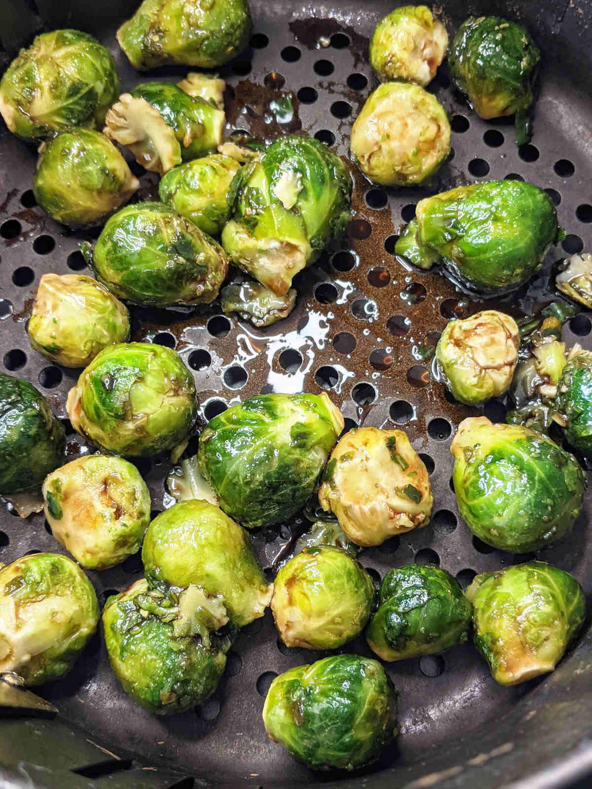 Frozen brussels sprouts in air fryer basket.