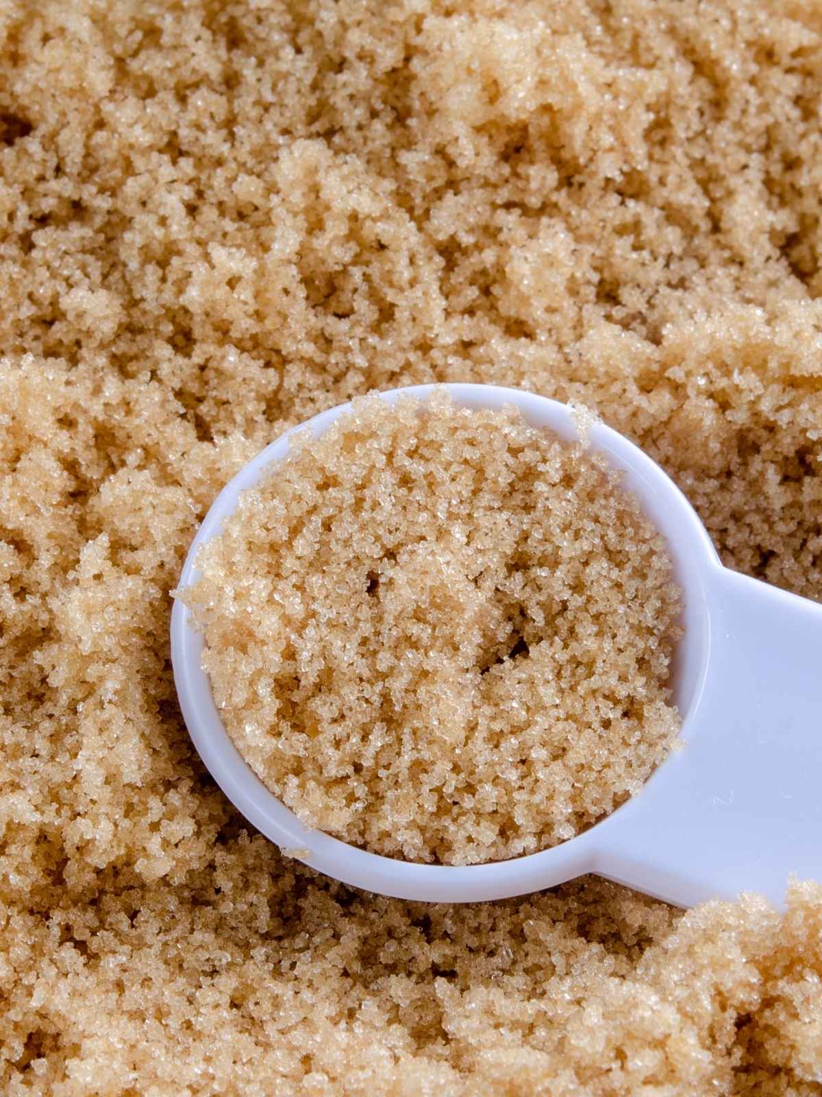 Light brown sugar with a measuring spoon.