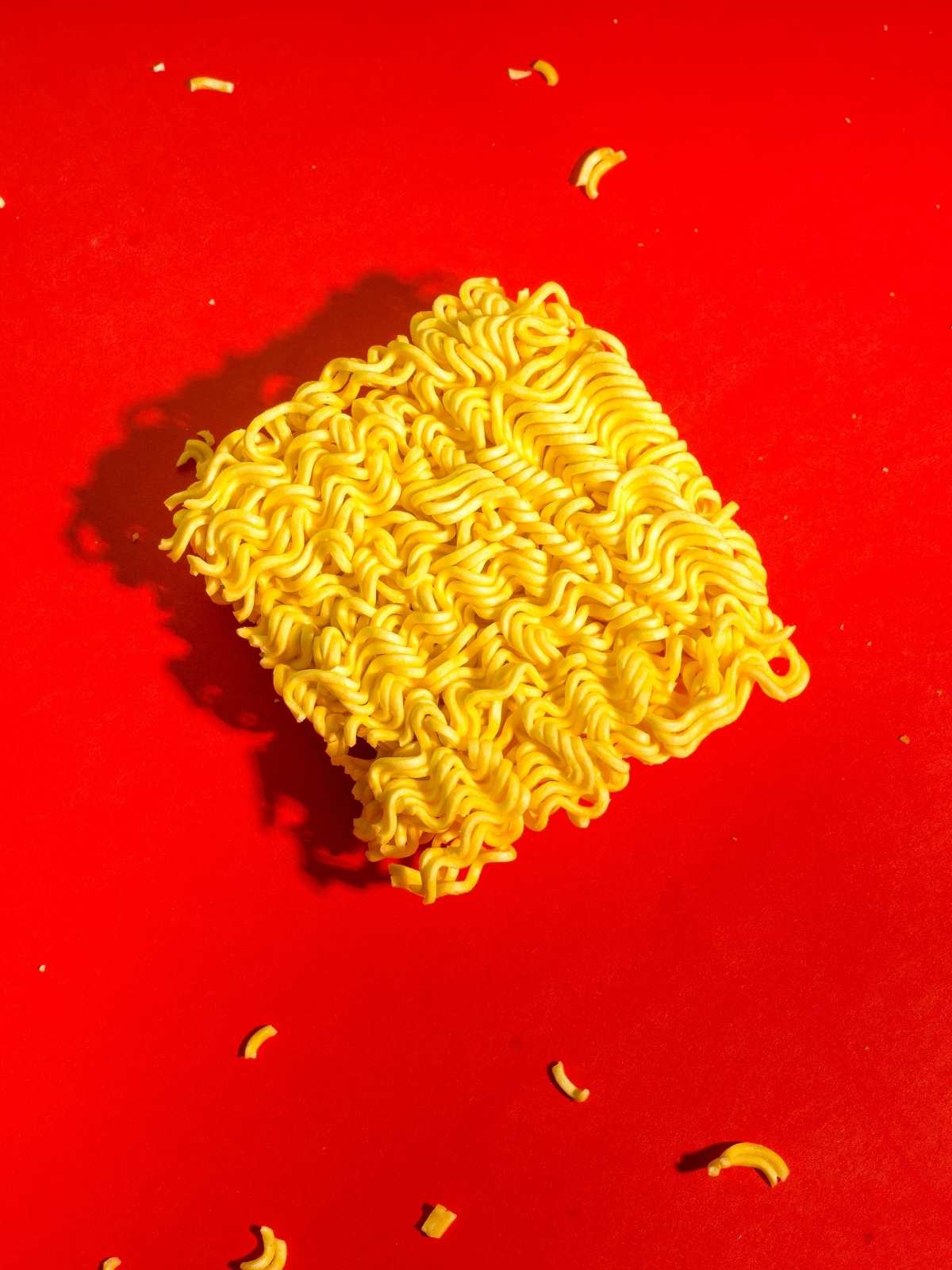 Red background with a pack of dry ramen instant noodles.