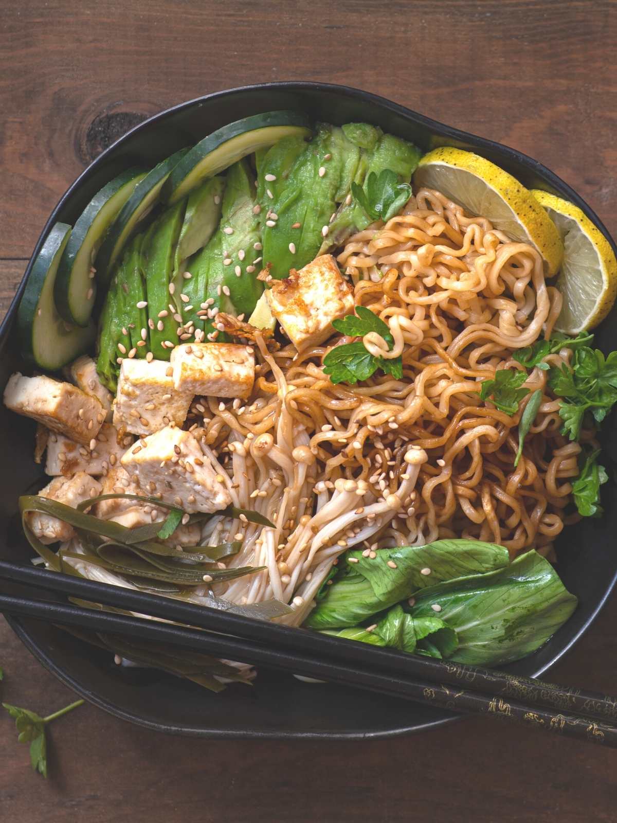 Bowl filled with vegan ramen topped with tofu and vegetables.