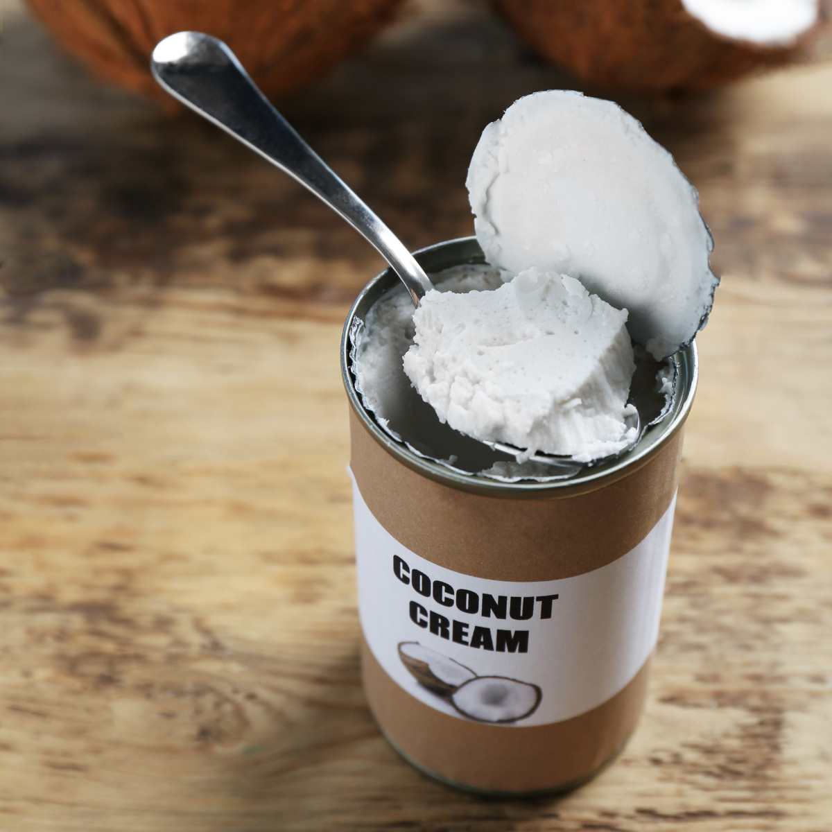 Can of coconut cream open with a spoon scooping some out.